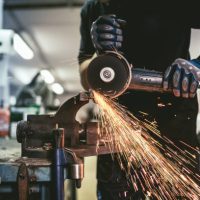 Heavy industry worker cutting steel with an angle grinder.  ( Industry concept )