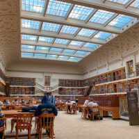 State library of NSW with students and people studying and reading. The State Library of NSW is a large reference and research library open to the public. It is the oldest library in Sydney, Australia.