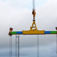 Container Spreader Device Hooked at Crane in Port