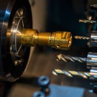 The  operation of multi-tasking CNC lathe machine swiss type cutting the hi-precision part. The hi-technology pipe connector parts by CNC turning machine.