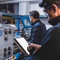 Mechanical technicians operative of cnc milling cutting machine center at tool workshop. CNC metalwork.