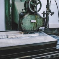 Close up shot of the CNC high-speed gun-drill machine drilling the water channel of injection mould cutting the parts with oil coolant method and simultaneous cooling in a metal manufacturing factory.
