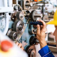 Blue collar worker or engineer working in industrial production plant, dealing with metal processing, hydraulic machinery, production lines and other processing industry machines. Image taken in Serbia, Europe.