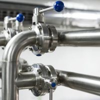 The system of pipelines from stainless steel with ball valves. Abstract industrial background.